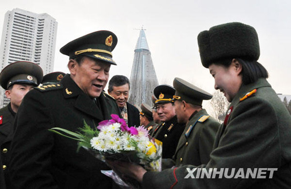 11月22日，中國國務委員兼國防部長梁光烈（左）在平壤祖國解放戰(zhàn)爭勝利紀念塔廣場接受獻花。新華社記者姚西蒙攝