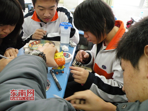 同學(xué)們?cè)诶蠋煹闹笇?dǎo)下制作心愿卡作品。