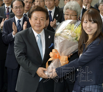 12月18日，高票當(dāng)選東京都新知事的豬瀨直樹正式到任。圖為豬瀨從政府職員手中接過花束。(共同社)