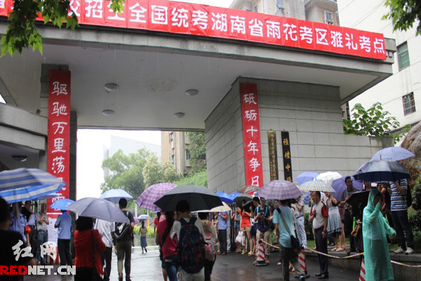 高考學(xué)子冒雨進(jìn)入考場(chǎng)。