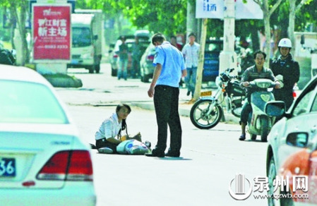 女孩從摩的上摔下，跌坐路中央，恰遇社區(qū)聯(lián)防巡邏人員扶起。