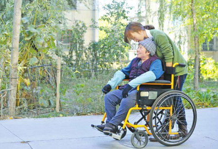 10月11日，張學(xué)琴用輪椅推著母親在校園里散步。