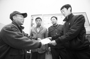 劉大爺莊重地將感謝信交到車隊隊長的手中。本報記者 李志華 攝