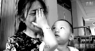 視頻中“小中寶”看到奶奶為他掉眼淚，就伸手為奶奶抹去眼淚。視頻截圖 