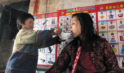 小孫悅為臥床的母親喂飯。