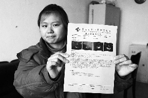 女孩眼含淚水向記者出示自己母親的診斷報告，希望好心人可以幫幫她的母親?！　z影 李自強(qiáng)