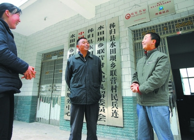  張義波(右)和村主任等村干部商談工作。