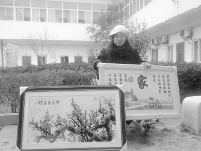 胡海珠和她繪制的“十字繡”。馮勁松 攝