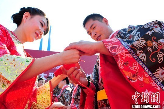 9月1日，一場別開生面的“重溫漢唐風”漢式集體婚禮在泉城濟南舉行，72名新人身著傳統(tǒng)漢服喜結(jié)良緣，并在許愿墻上許下“千年共枕眠，一世永相愛”心愿。圖為新人解纓結(jié)發(fā)。中新社發(fā) 張勇 攝