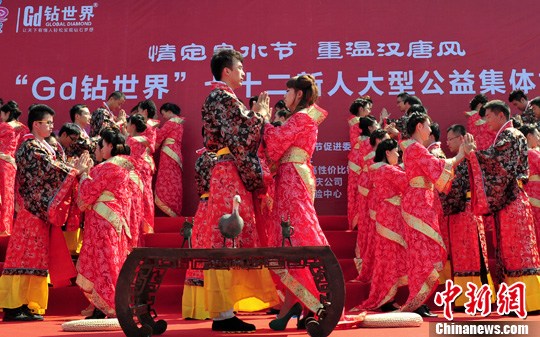 9月1日，一場(chǎng)別開(kāi)生面的“重溫漢唐風(fēng)”漢式集體婚禮在泉城濟(jì)南舉行，72名新人身著傳統(tǒng)漢服喜結(jié)良緣，并在許愿墻上許下“千年共枕眠，一世永相愛(ài)”心愿。圖為新人解纓結(jié)發(fā)。中新社發(fā) 張勇 攝