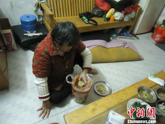17日下午，56歲小兒麻痹癥患者張紅英爬在地板上找東西。 蘇路程 攝