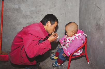 詹圓圓出門前給兒子喂飯。