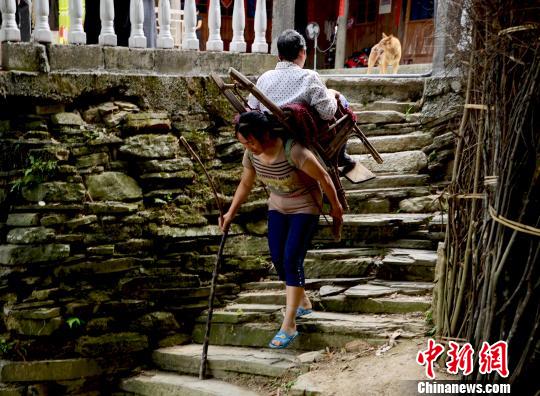 圖為趙先瓊背著婆婆出村就醫(yī)（資料圖）。