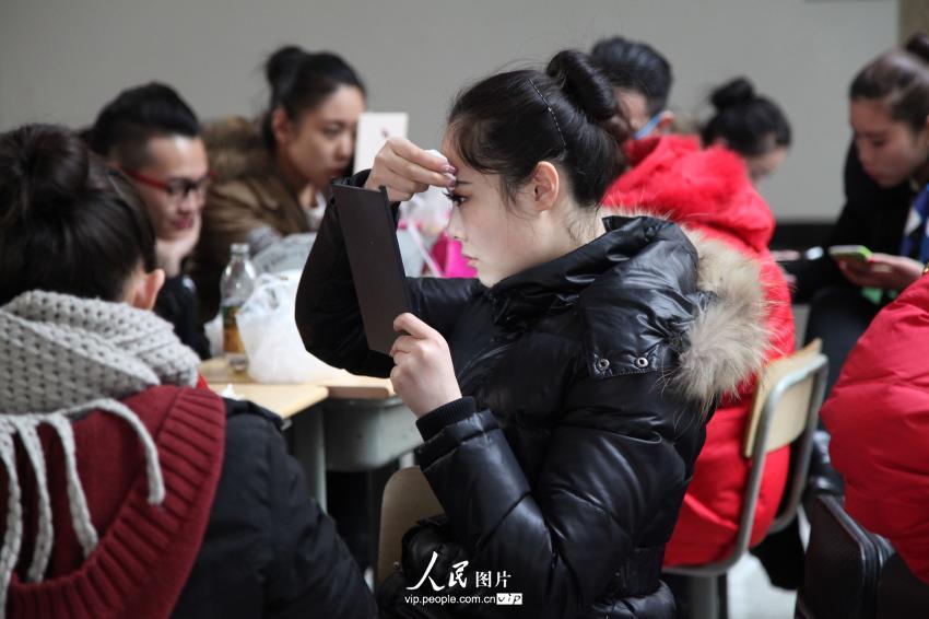 2014年2月17日，山東濱州，藝考候考考生在濱州學(xué)院報(bào)名點(diǎn)化妝。