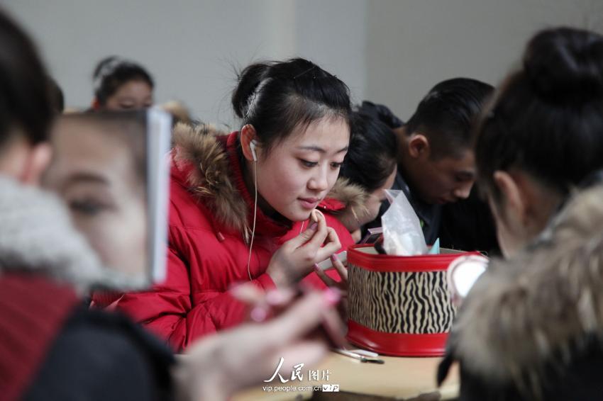 2014年2月17日，山東濱州，藝考候考考生在濱州學(xué)院報(bào)名點(diǎn)化妝。