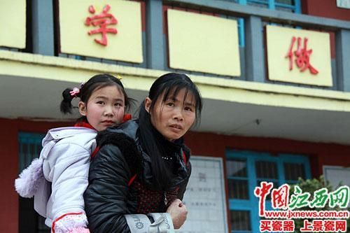 蘭愛紅背著女兒放學。
