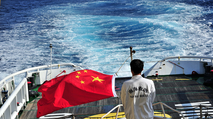 3月18日，水手李國棟在南海救101輪船甲板后部升起國旗。新華社記者 趙穎全攝
