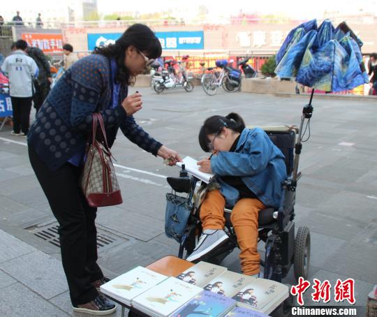 洛洛正在給買書的顧客簽名。 馮曉林 攝