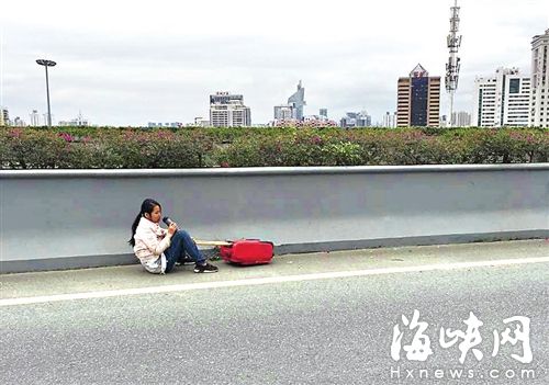 女子被拽下后，坐在三環(huán)路應(yīng)急車道上喝水