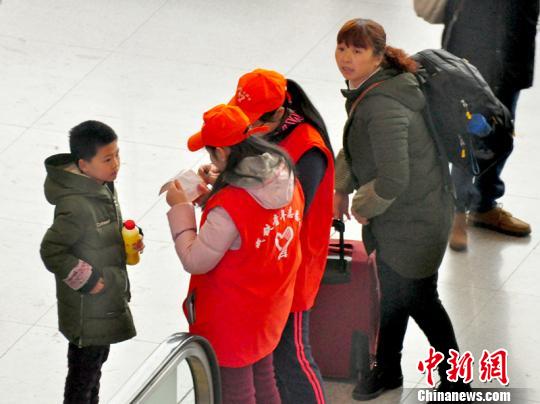鐵路青年志愿者為攜帶兒童出行的旅客提供咨詢解答?！钦鳌z