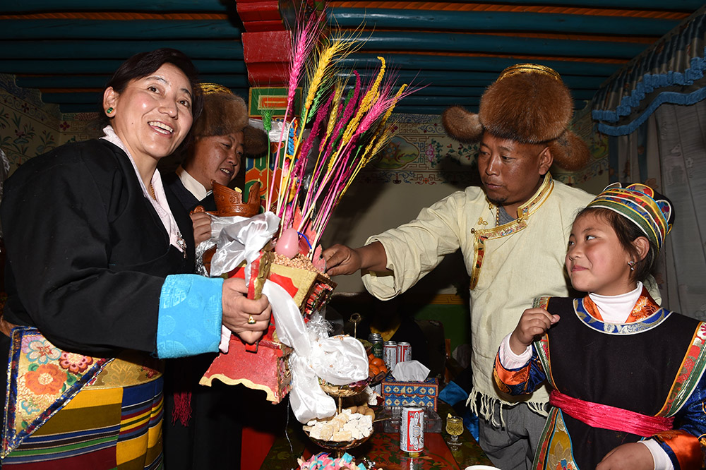 2月27日,拉薩市城關(guān)區(qū)阿壩林卡社區(qū)居民央拉(左)向鄰居敬獻(xiàn)“切瑪”。